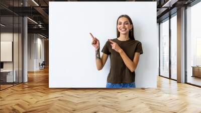 Young woman pointed side with a smile isolated on white background Wall mural